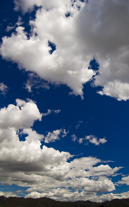 a view of the clouds and blue sky over water