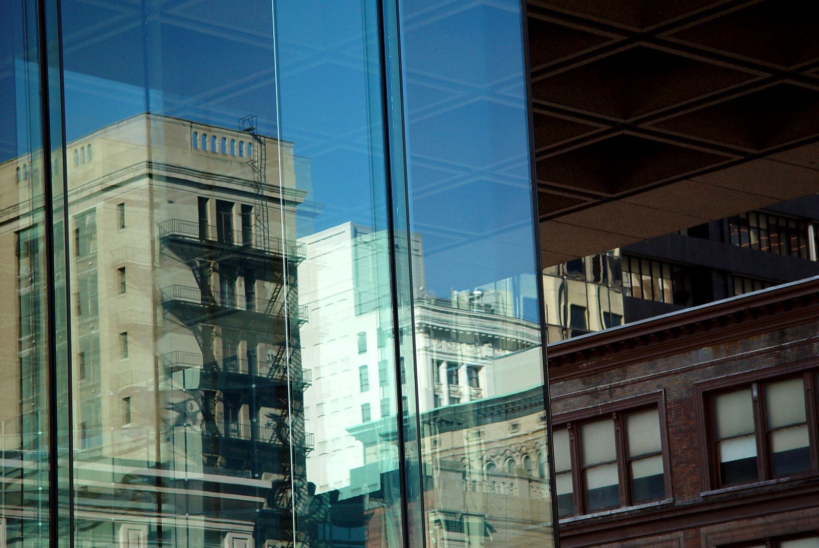 the reflection of buildings in a glass building