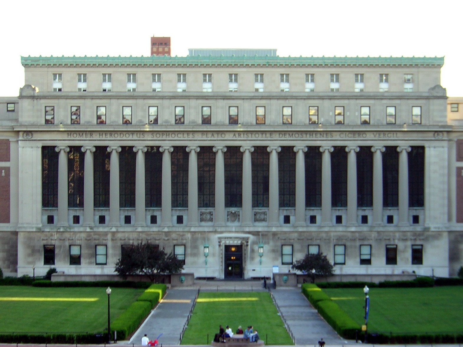 two people are sitting on a bench outside of an old building