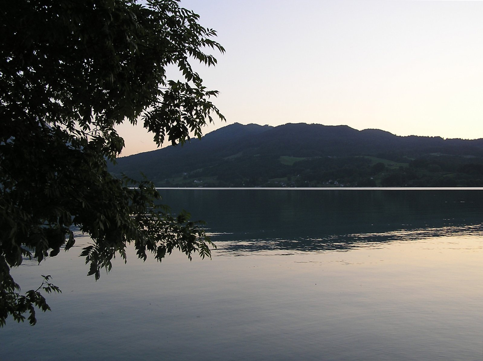 the view of a lake with mountains in the background