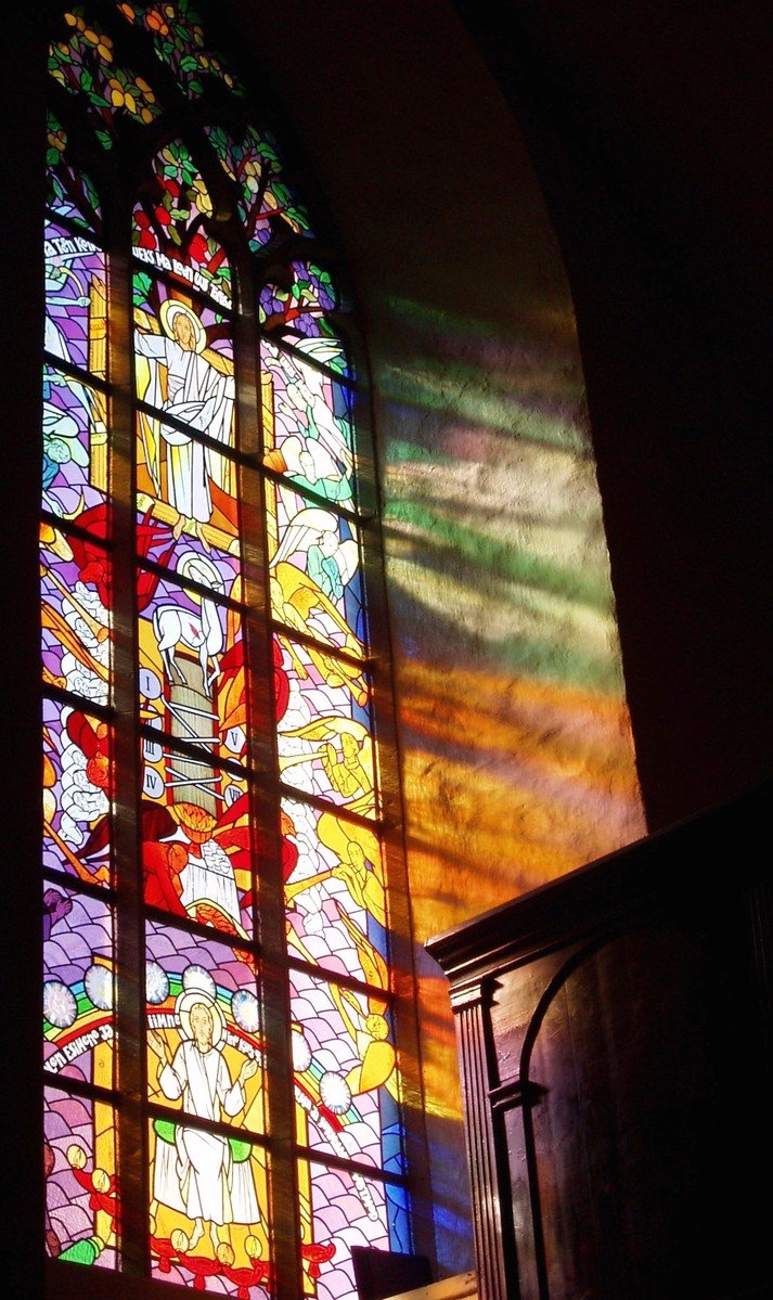a stained glass window behind a stair case