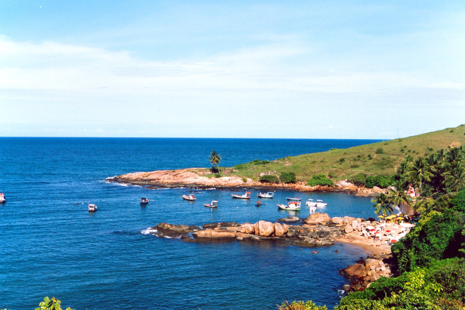 small boats on the blue waters near some land