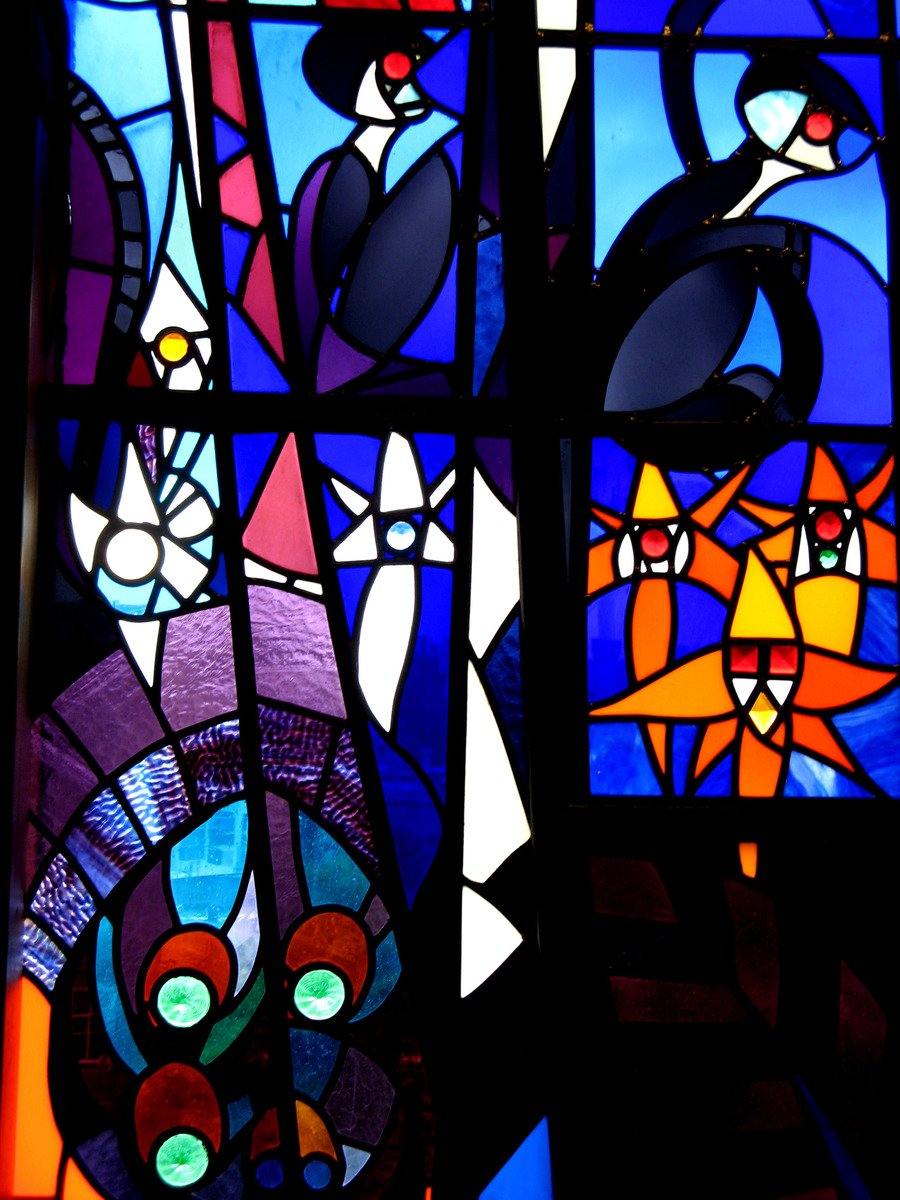 a very large colorful stain glass window with cats and animals in it