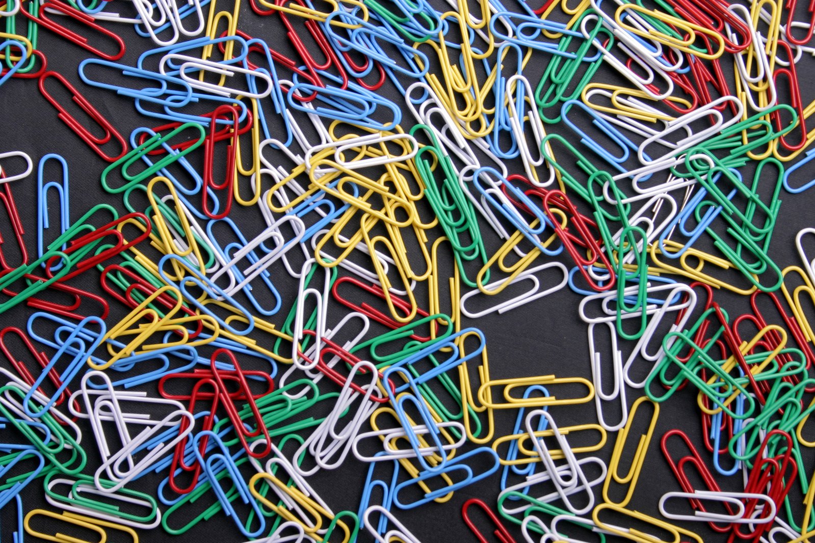 many pins and other colored paper clips are grouped together