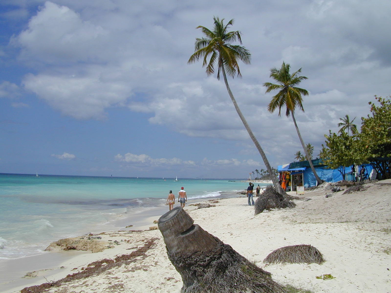 some people are on the beach with clear blue water