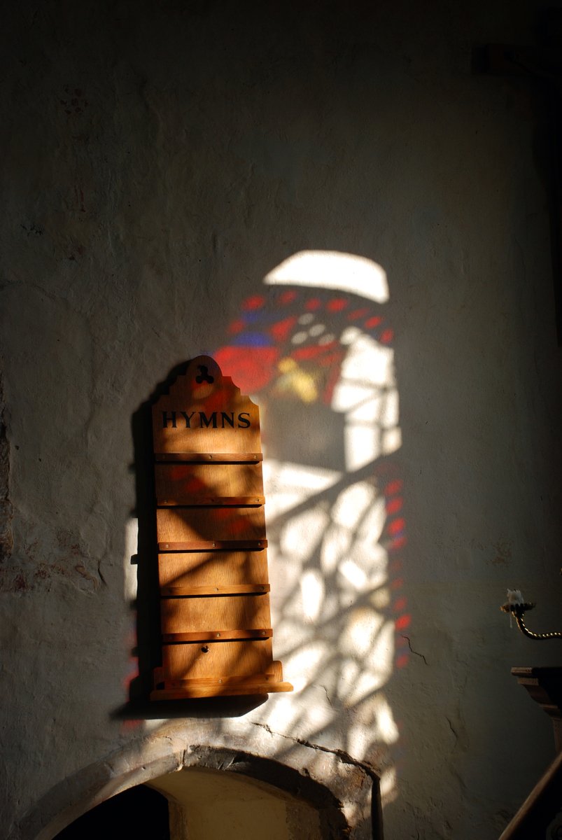 an old clock in a house with a shadow coming through the window