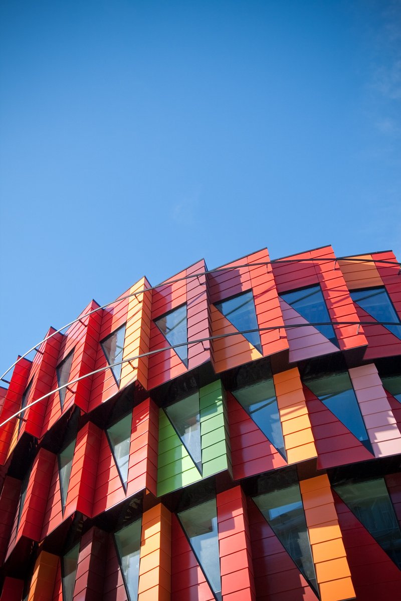 a colorful building has an irregular window design