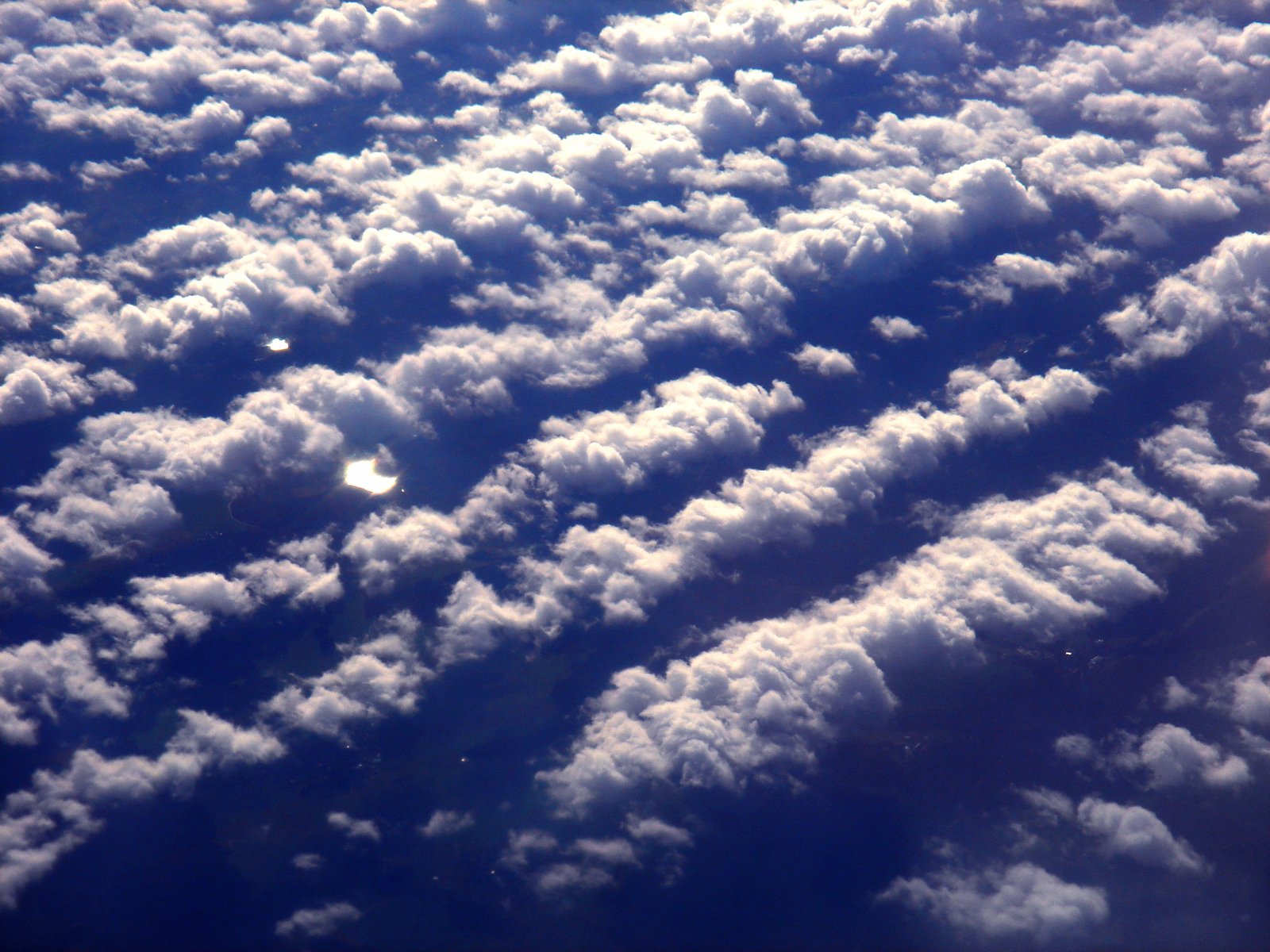 there are white clouds from above in the blue sky