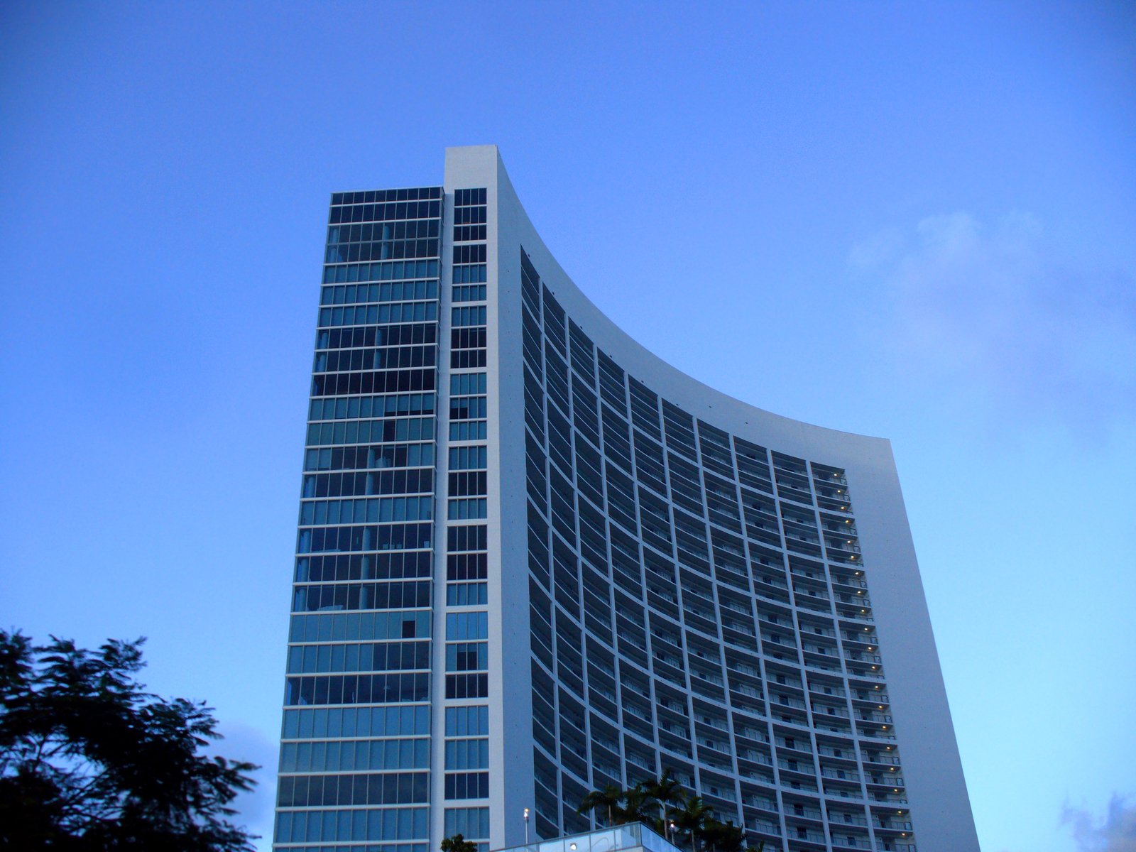 a tall building with windows sits in front of a blue sky