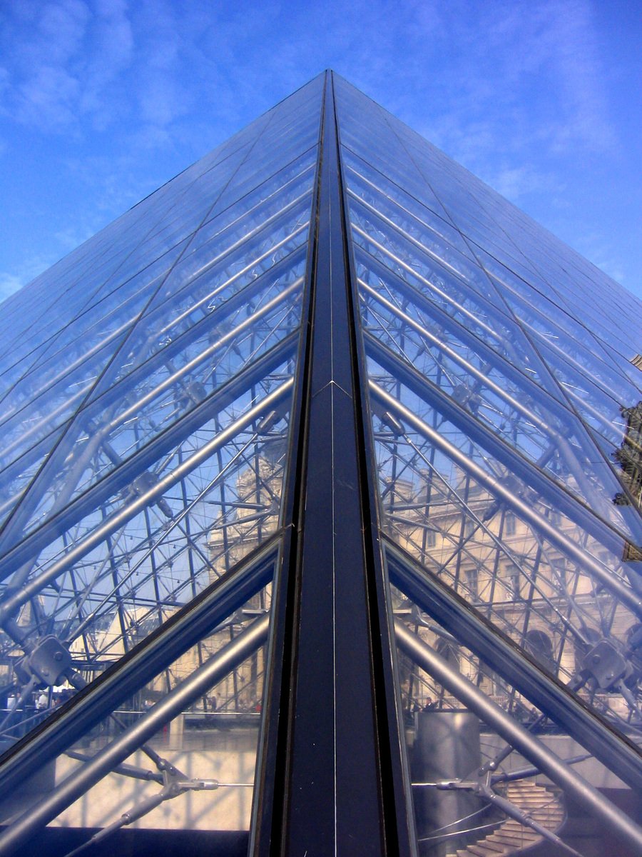 the top of a glass pyramid in front of a sky scr
