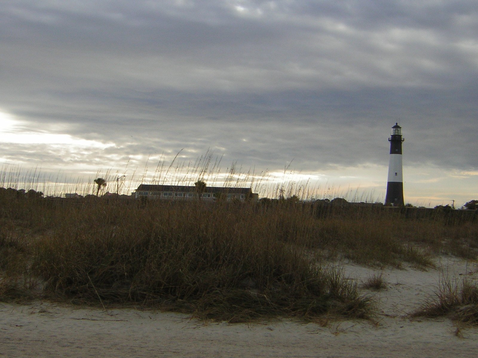an image of a house and lighthouse on a beach