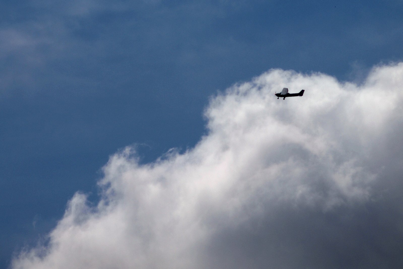 there is an airplane flying high above the clouds