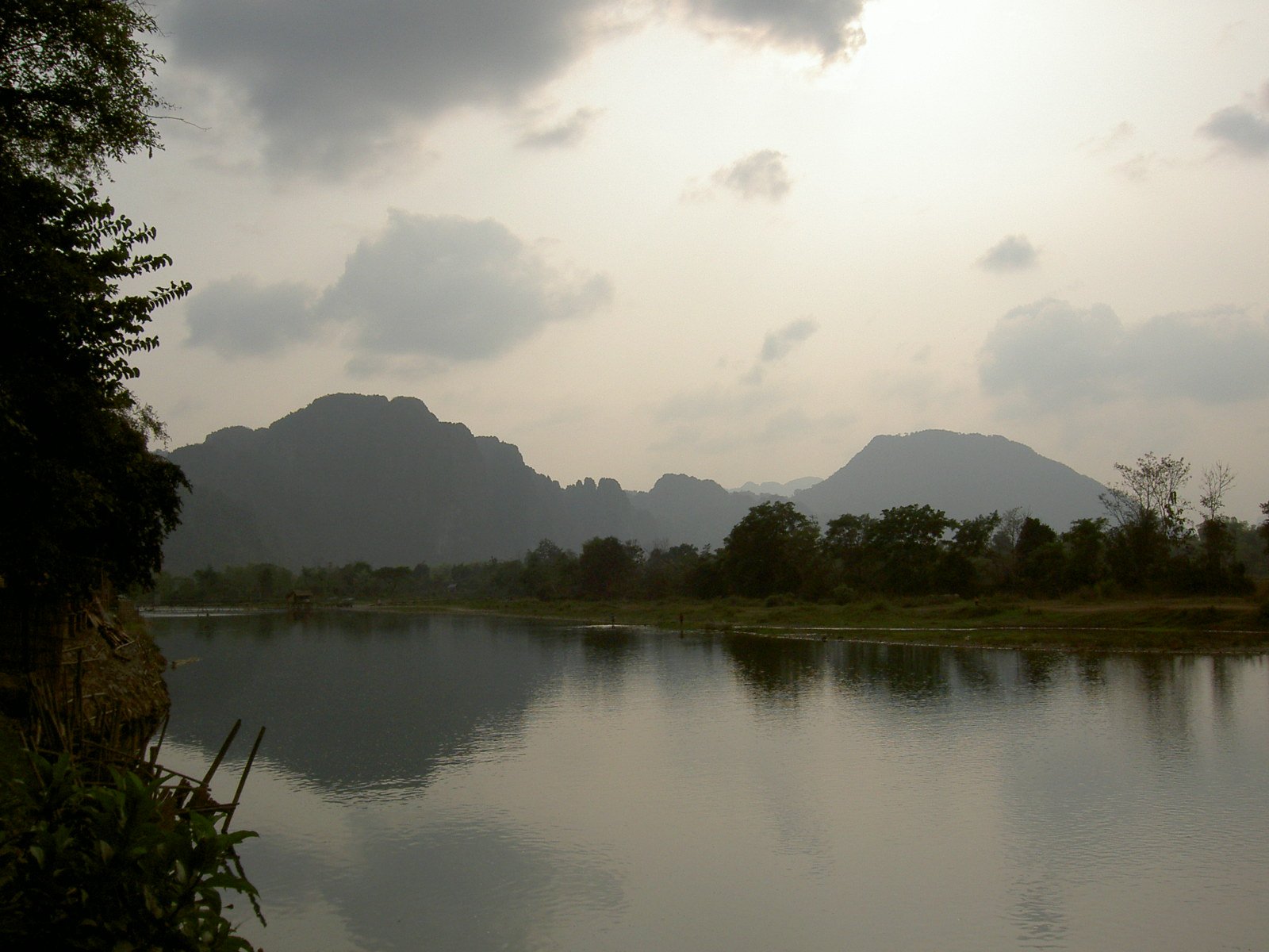 mountains and trees reflect in the calm waters