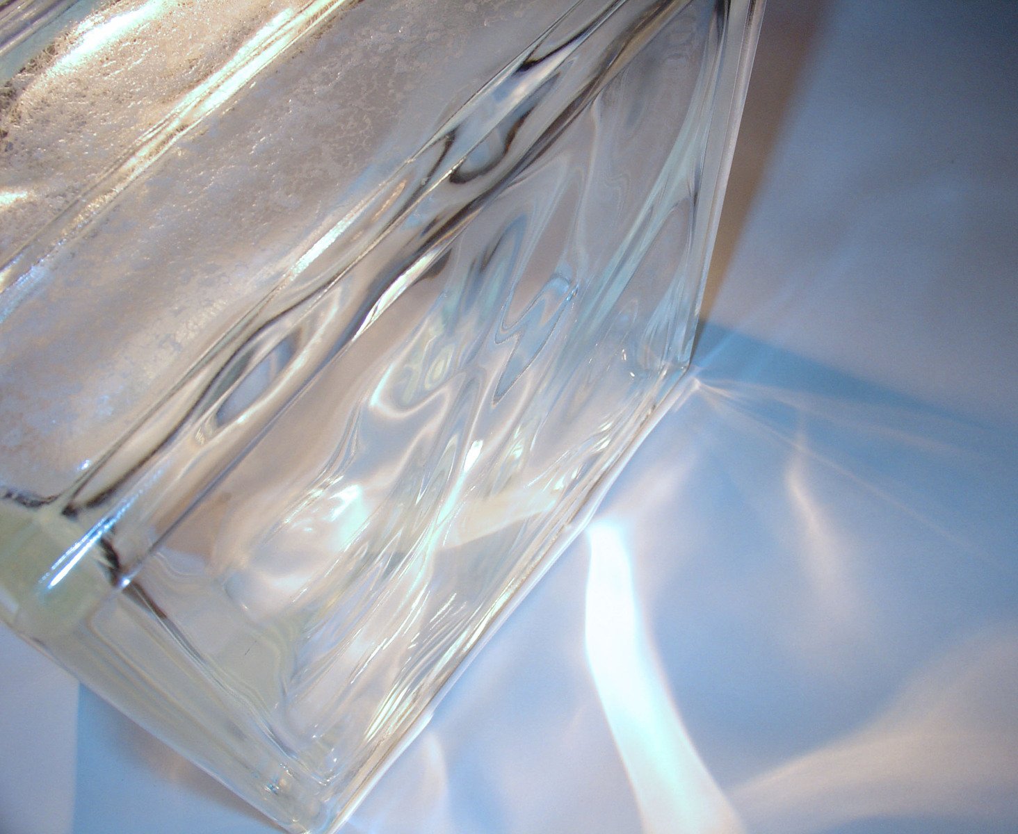 a glass vase is on a shiny white surface