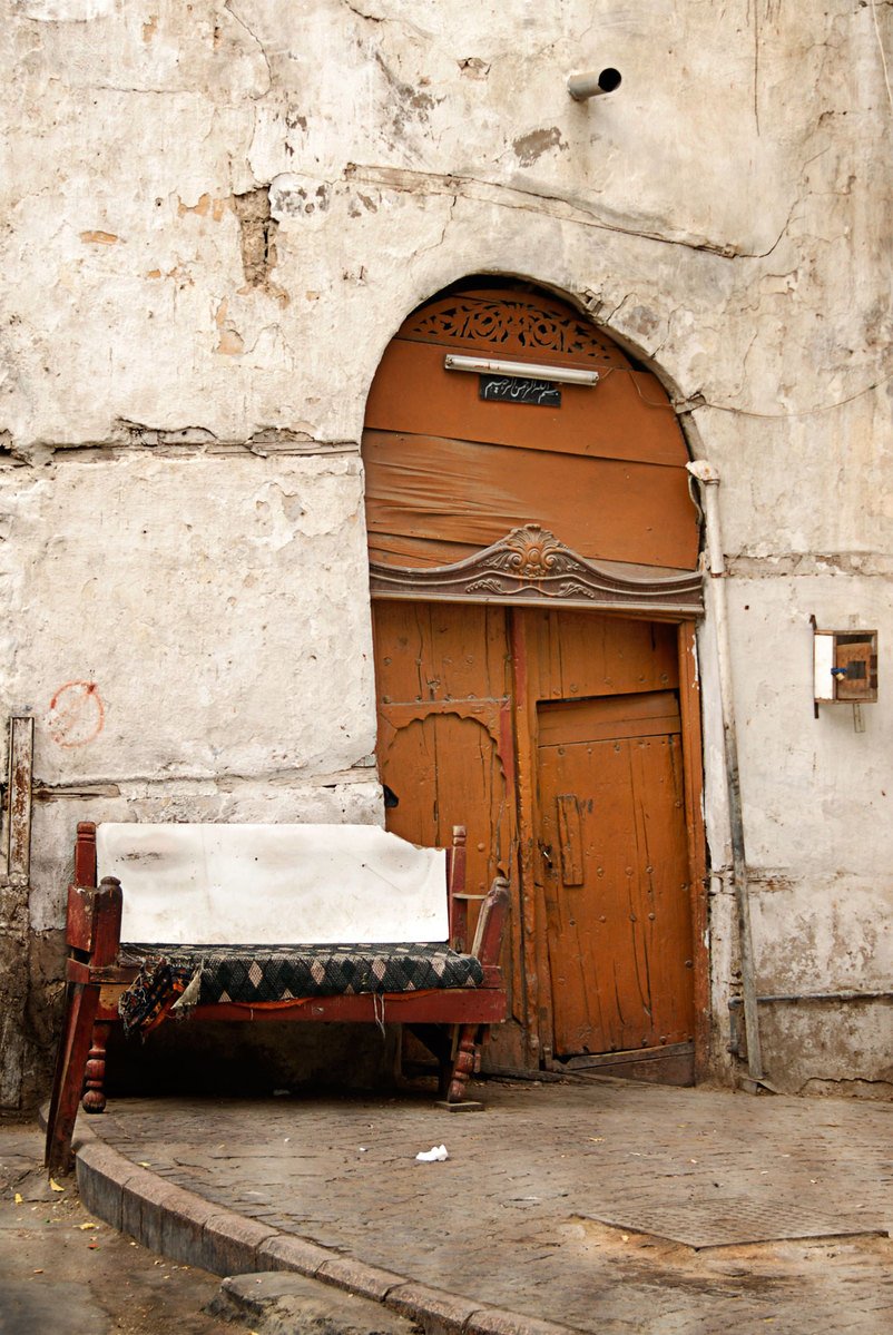 a bed sitting next to a brown door near a building
