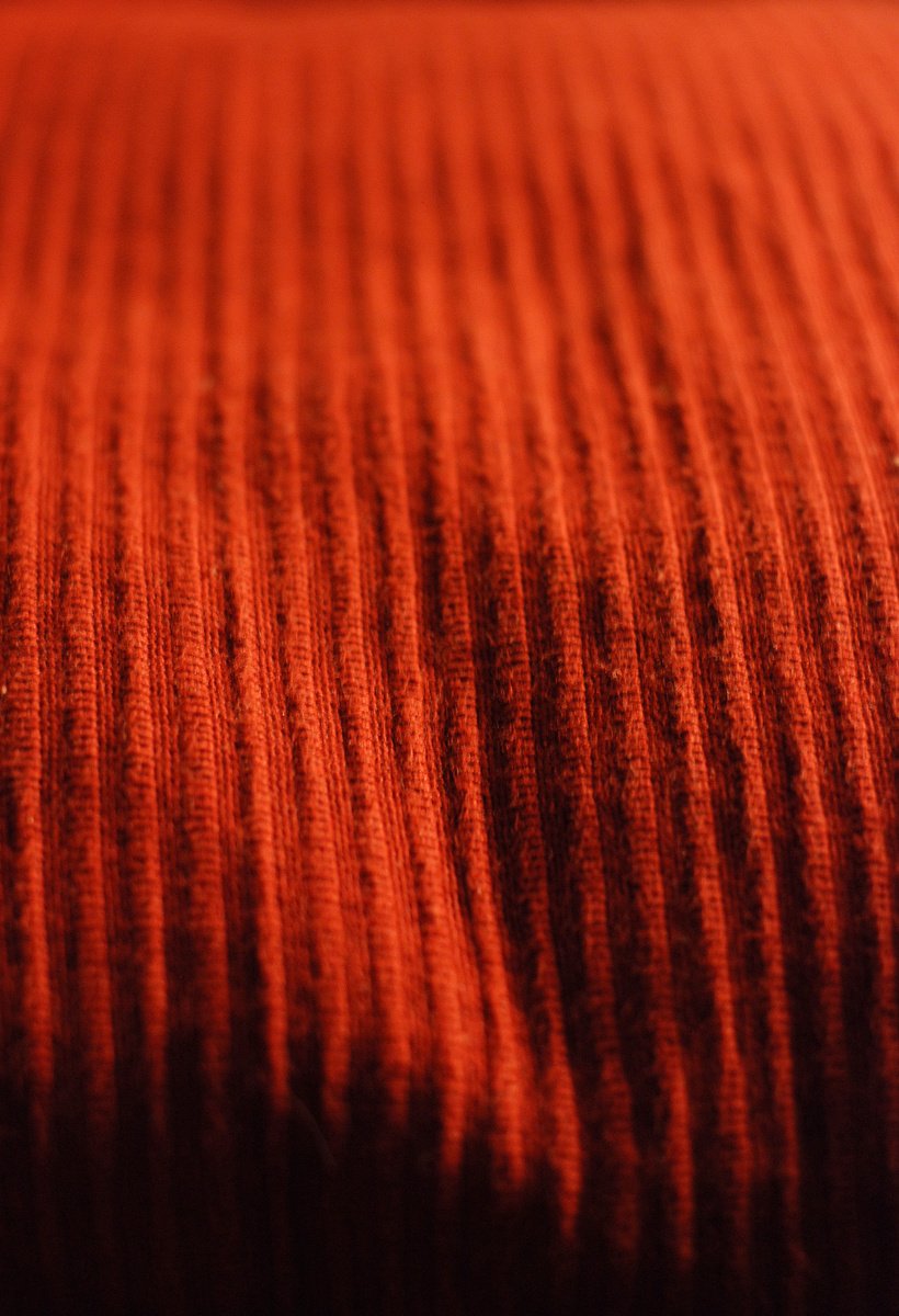 an orange blanket on top of a wooden floor