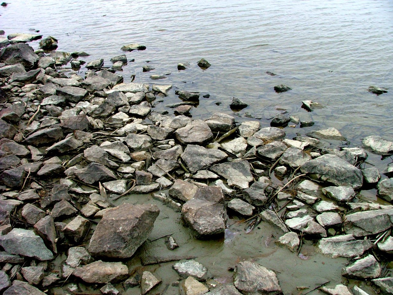 a large amount of rocks and water is next to a dock