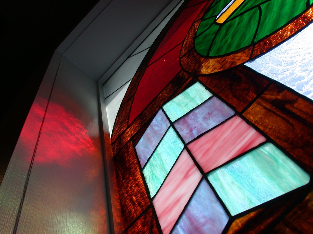 a large stained glass window is hanging in the wall