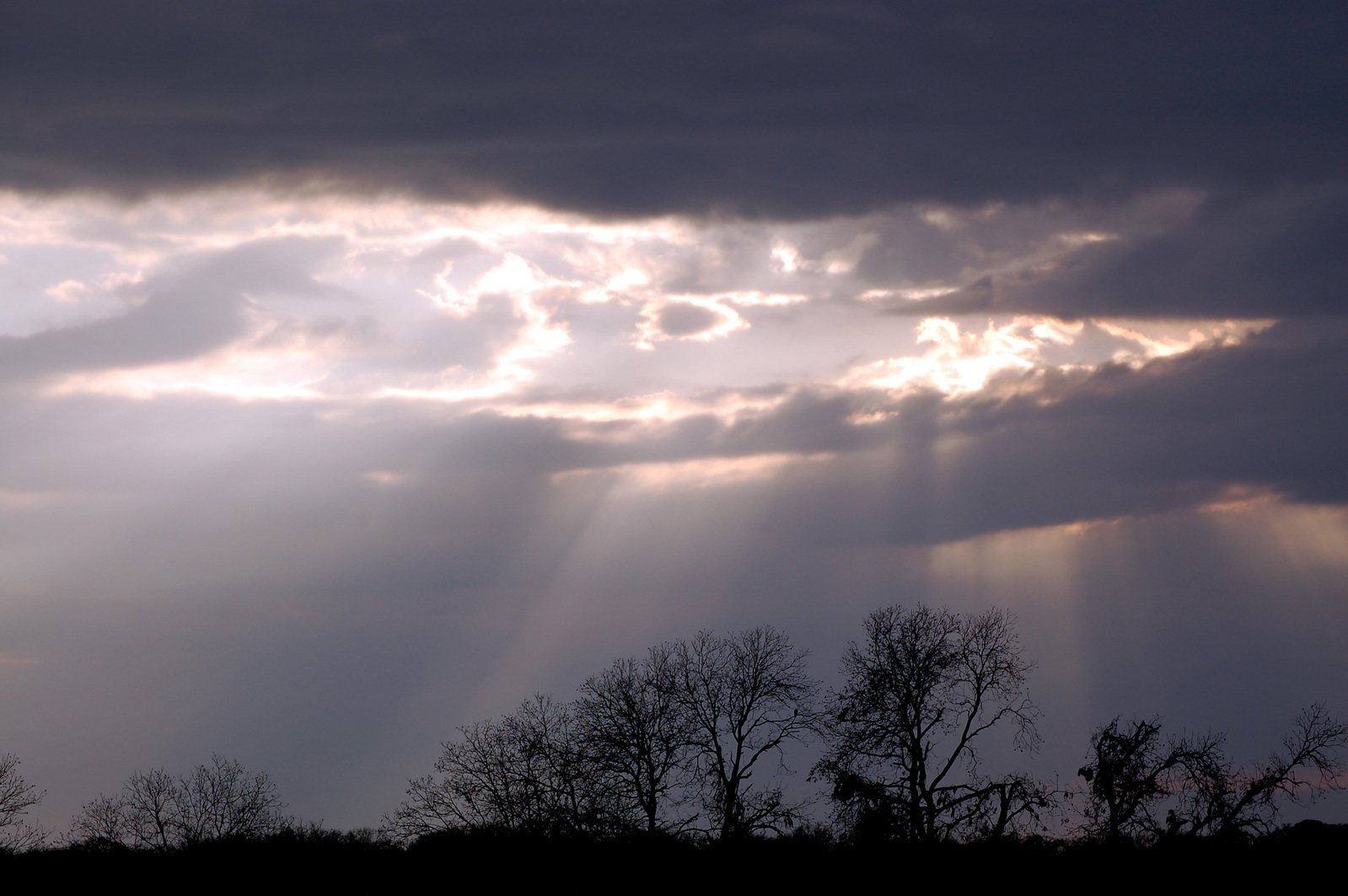 the sun shines through clouds in the sky