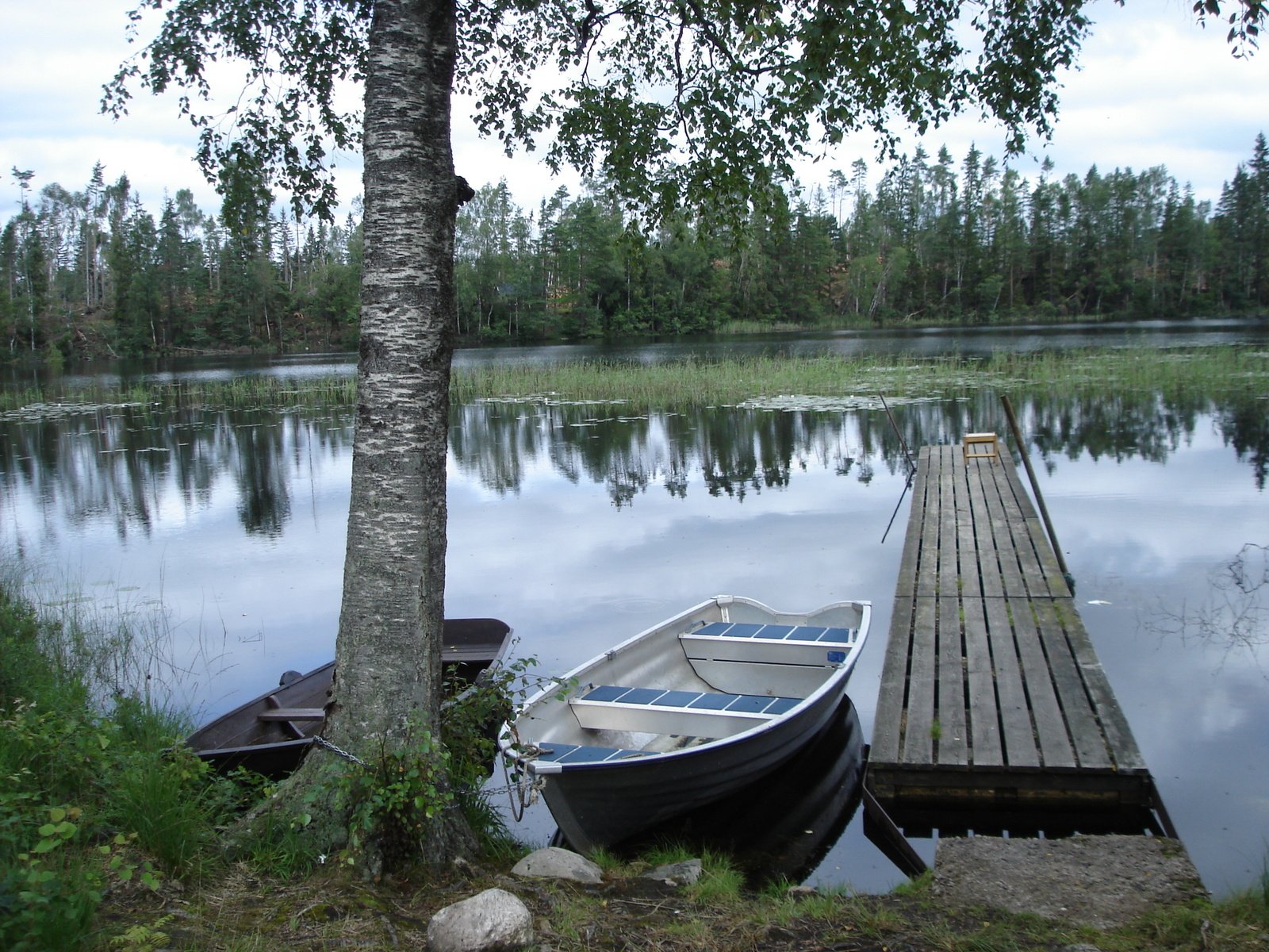 a small boat sits in the water at a dock