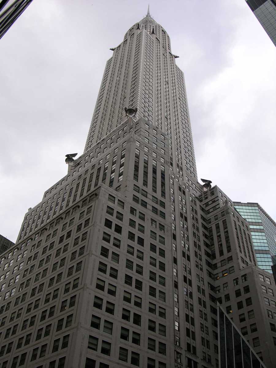 a tall gray building is pictured looking up