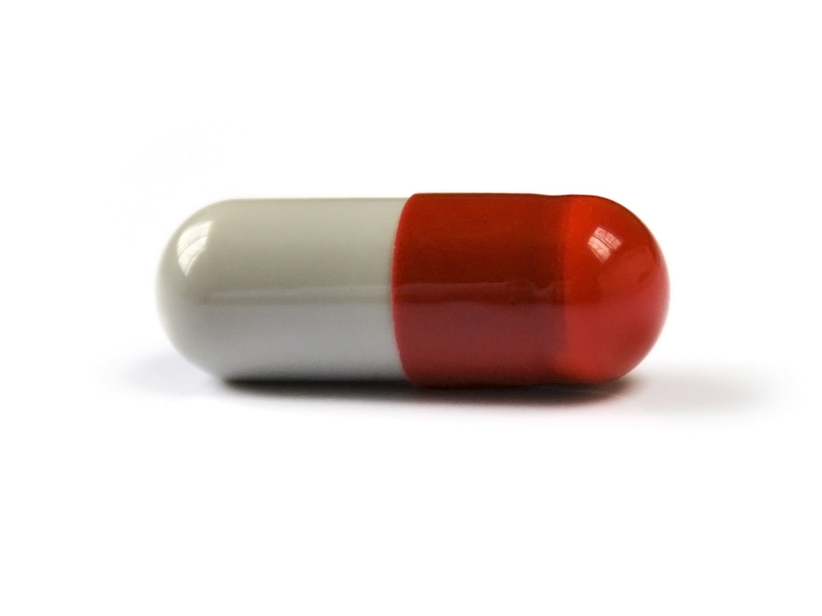 close up po of one pill pill bottle in white and red