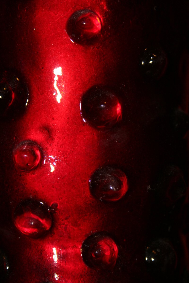 red glass bottles with lots of shiny drops on them