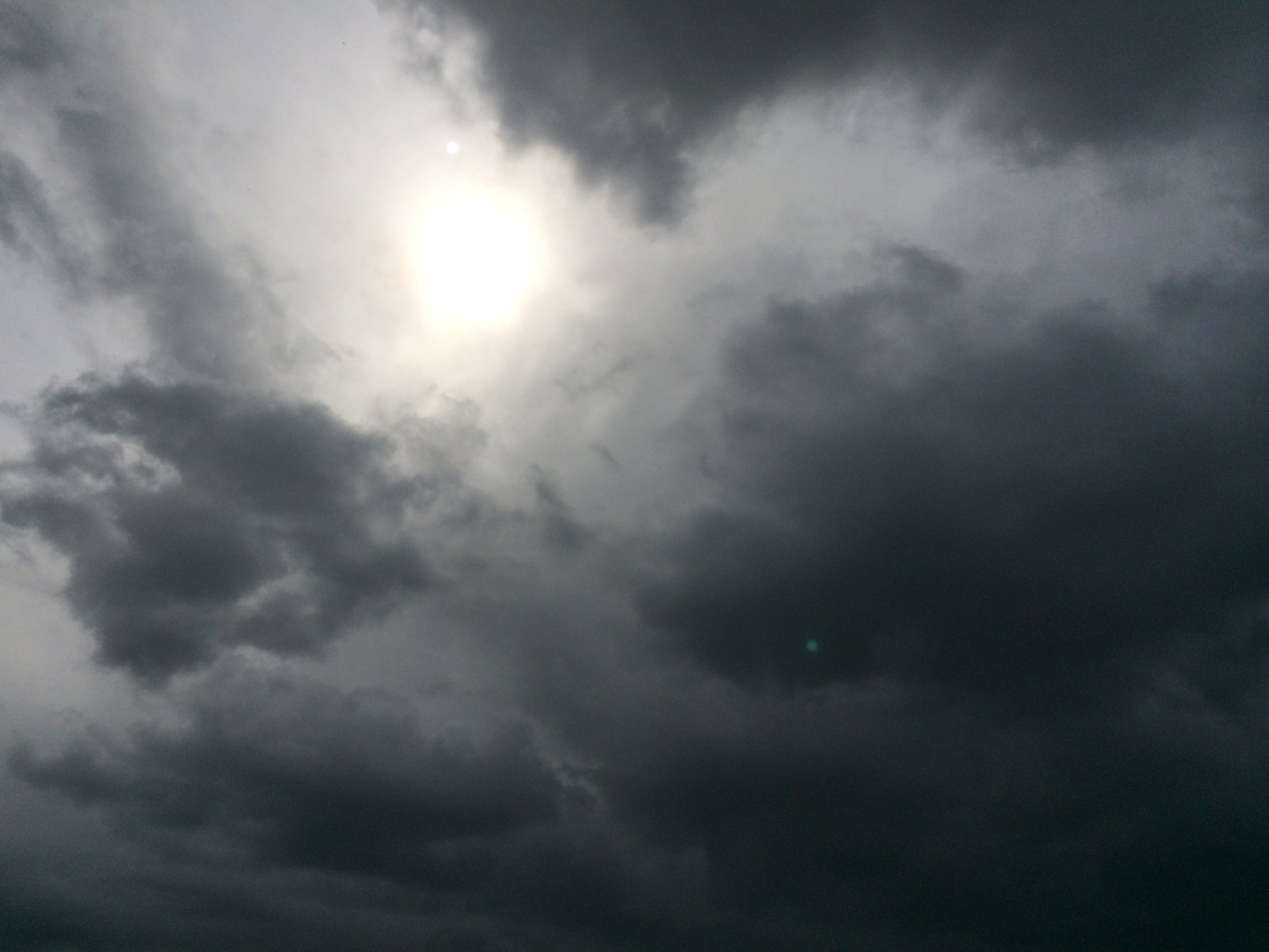 a cloudy sky with an airplane flying in the air