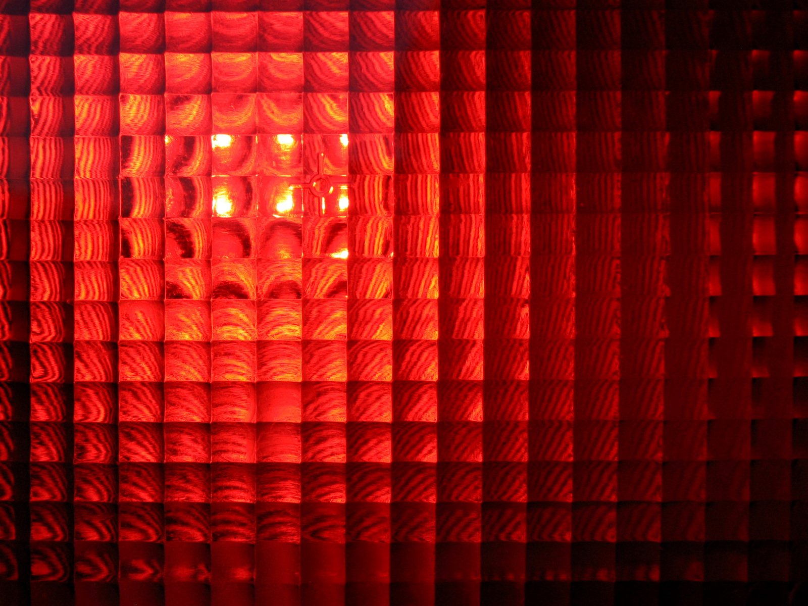 a red light shining through a pattern on curtains