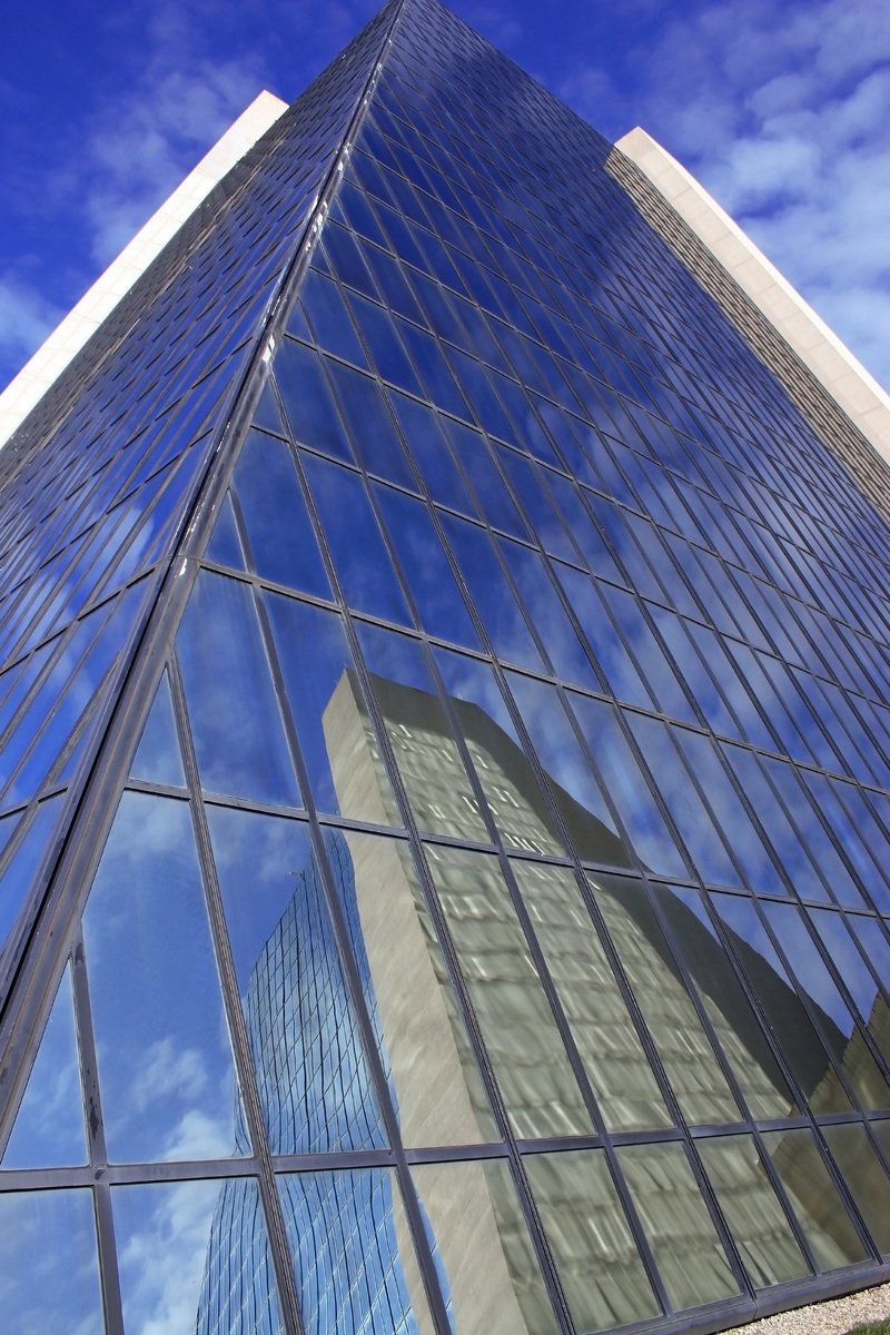 the view from below of the tall building through some windows