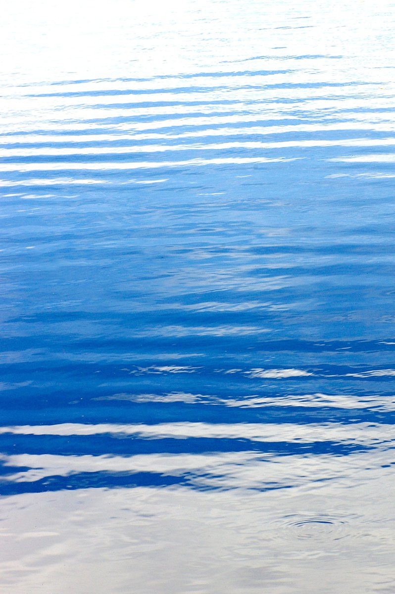 the calm sea has little waves, creating ripples in the water