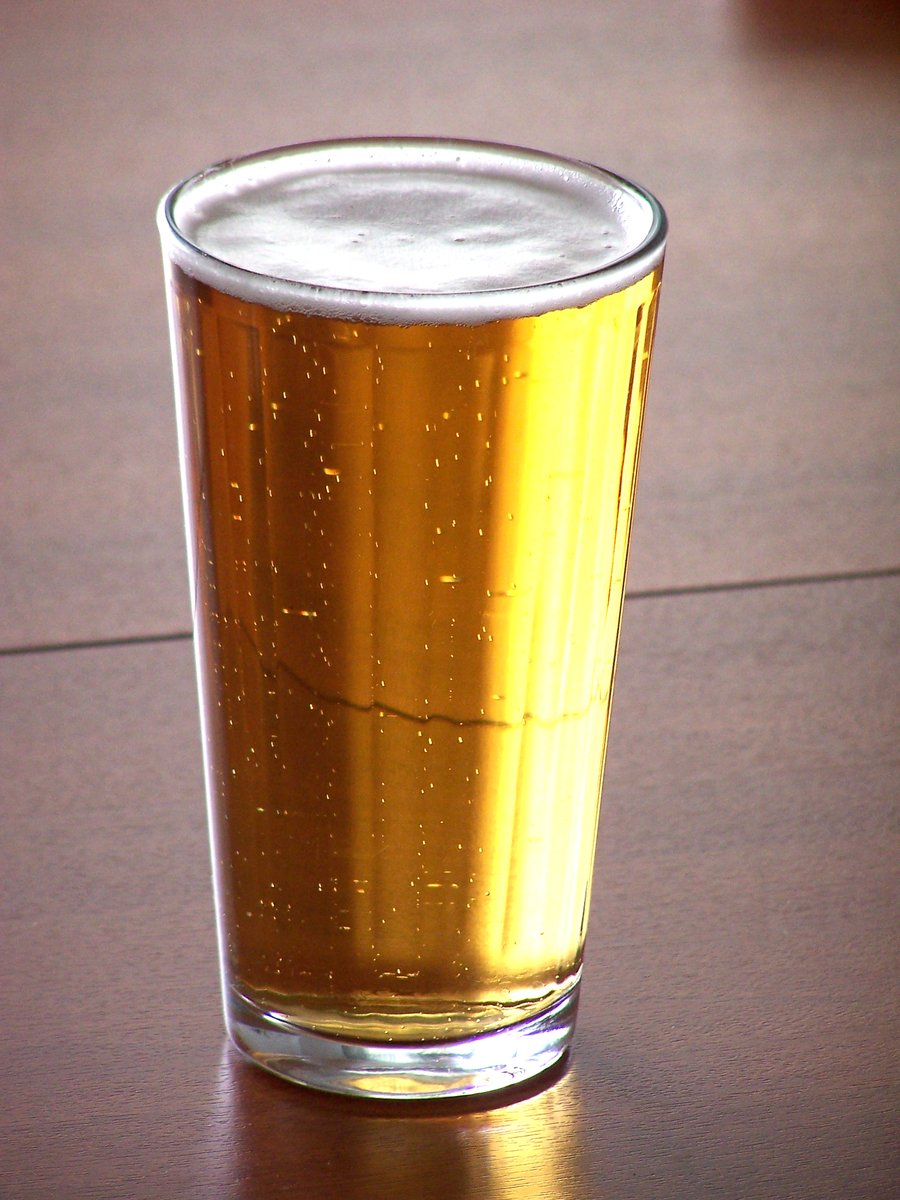 a glass of beer on a brown table