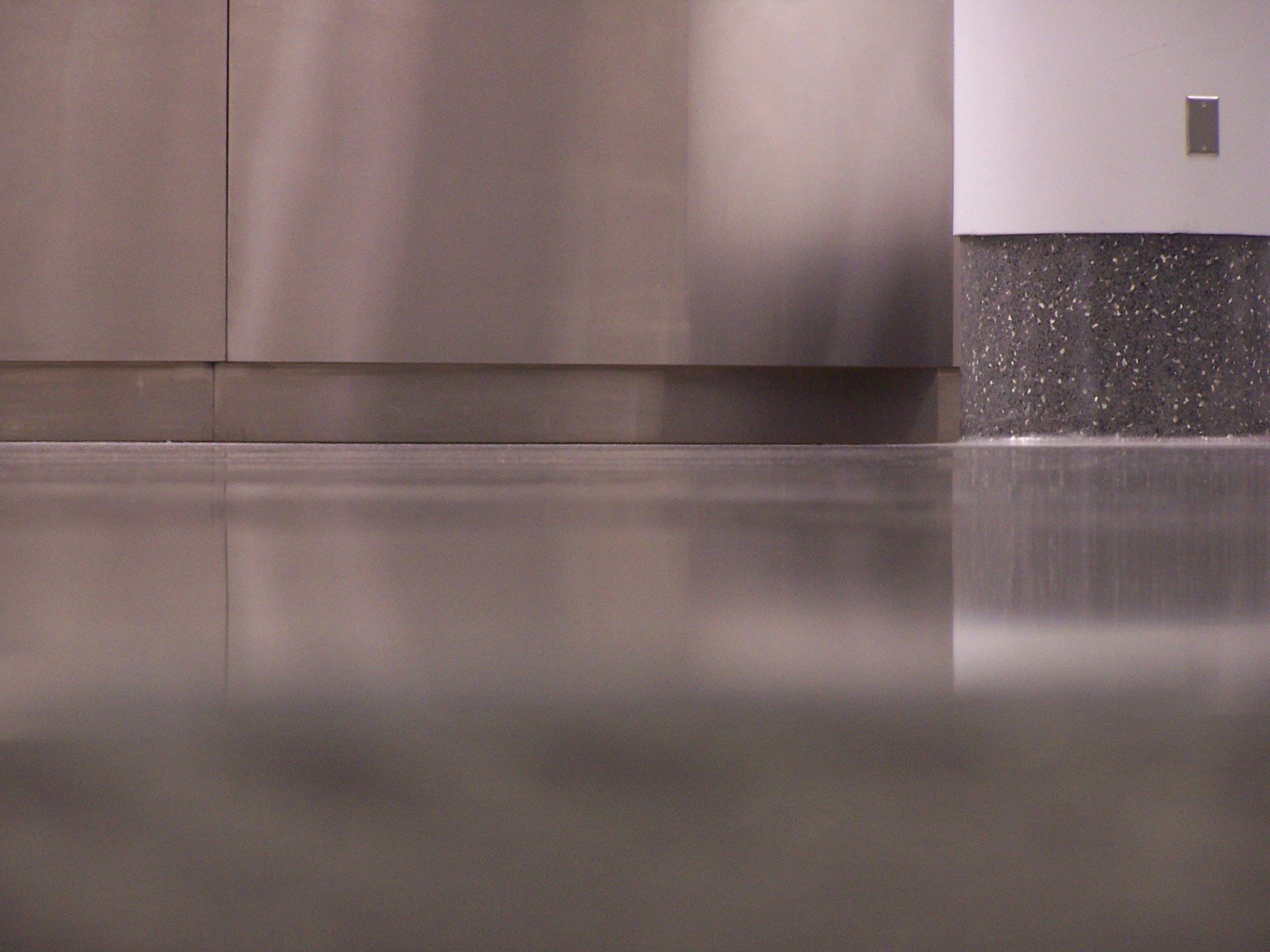 water sprinkled on a stainless steel wall with a splattered floor