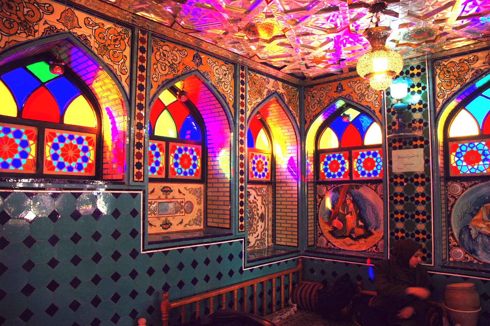 the interior of a restaurant with multiple colored stained glass windows