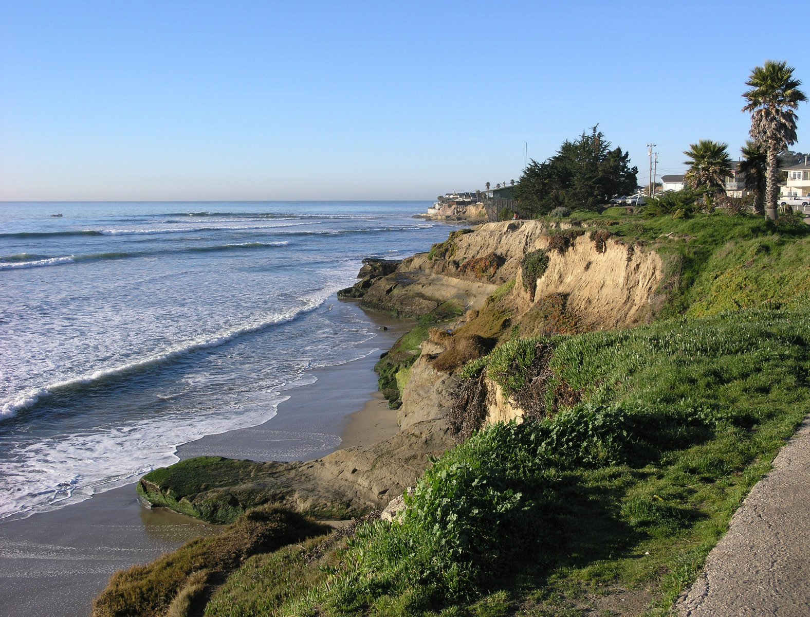 a large rock cliff in front of the ocean