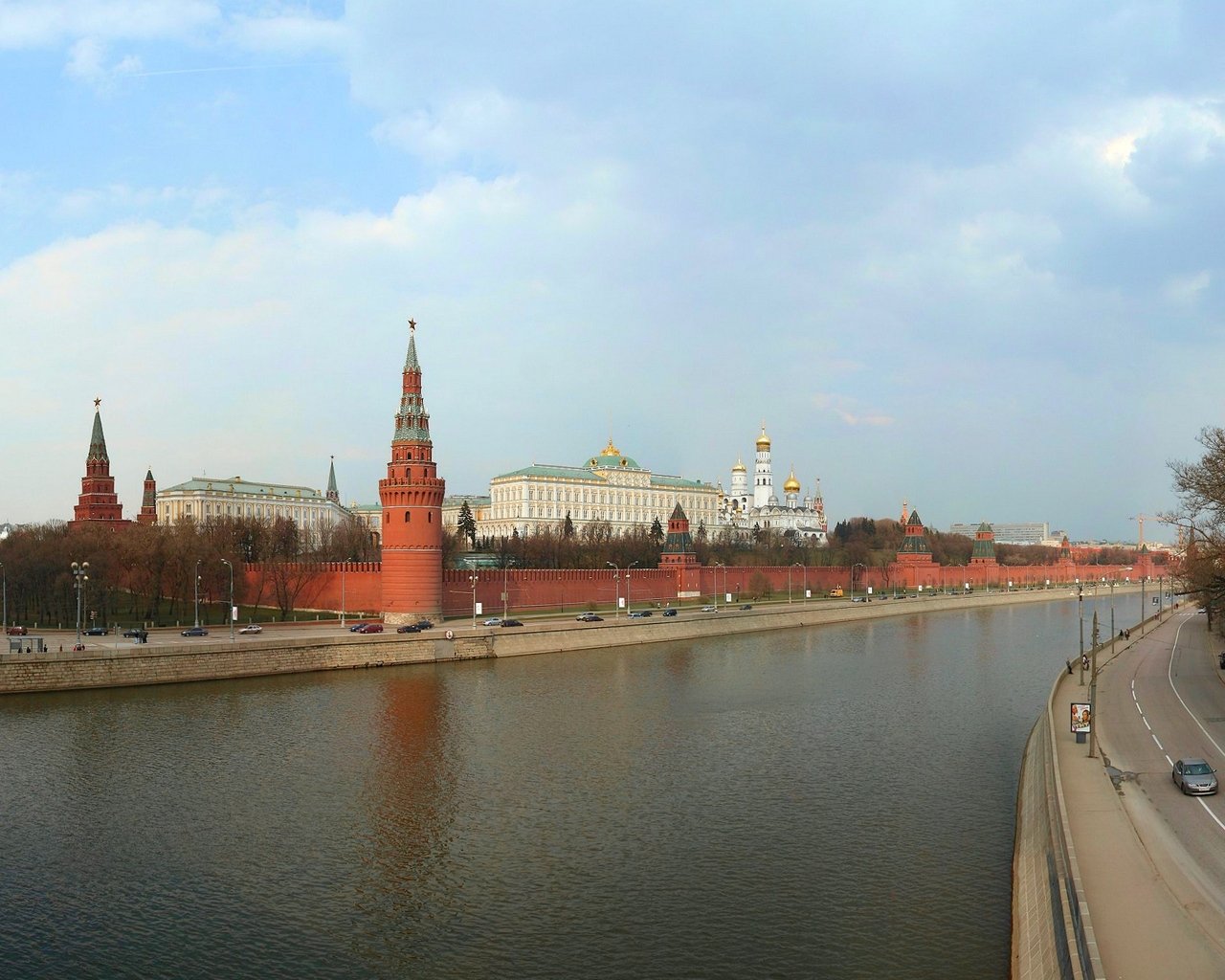 a river near some buildings and trees