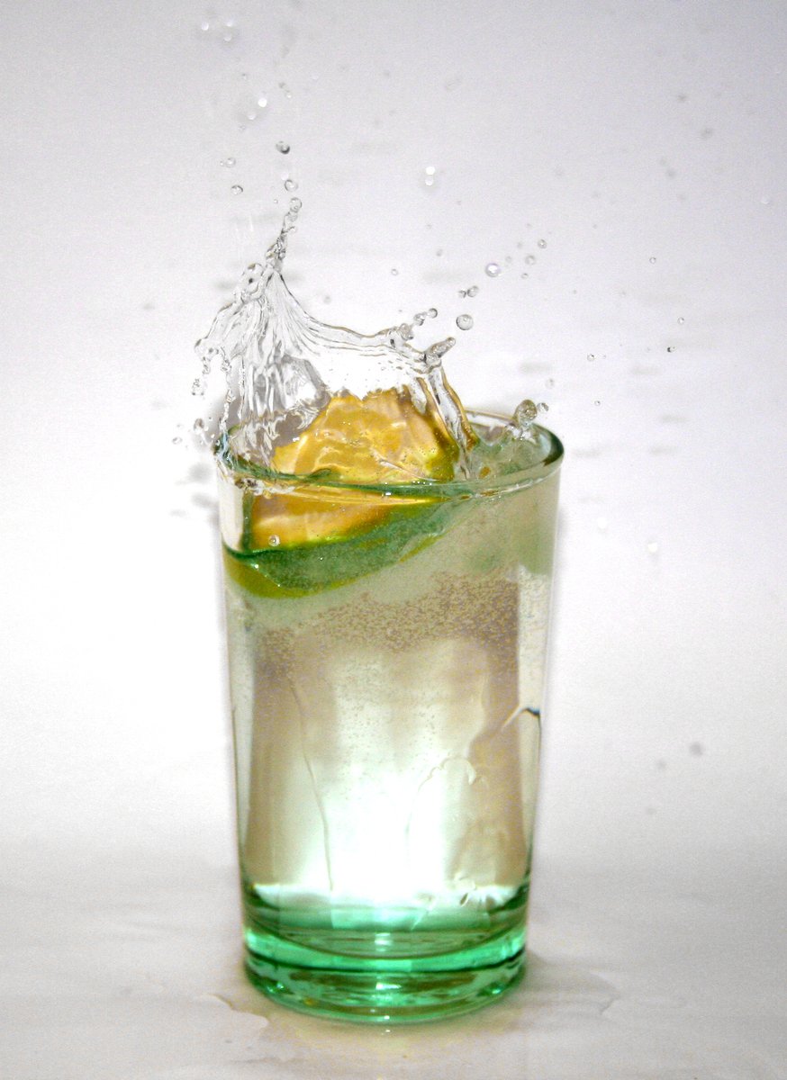a drink filled with water and lemons, and a slice of lime in the glass