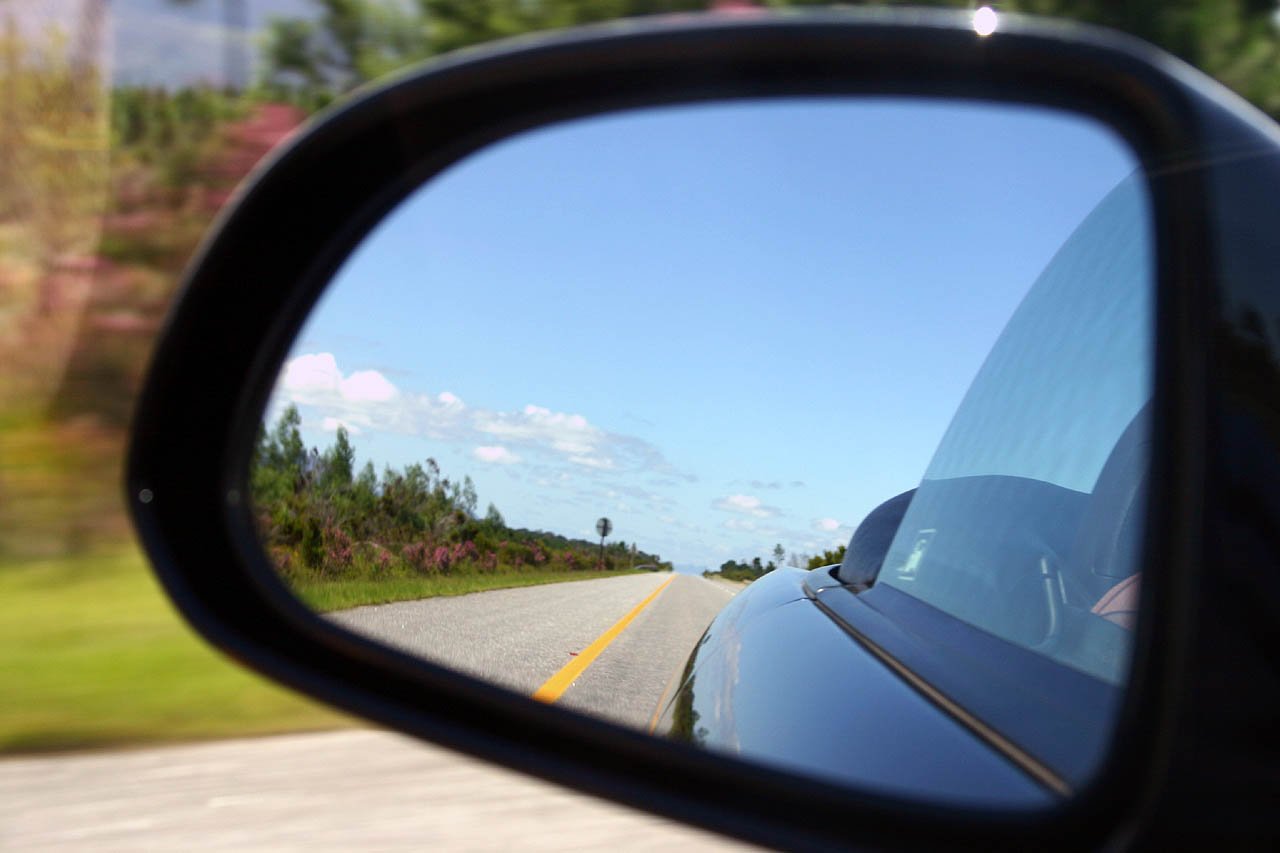 the reflection of a car in a side view mirror