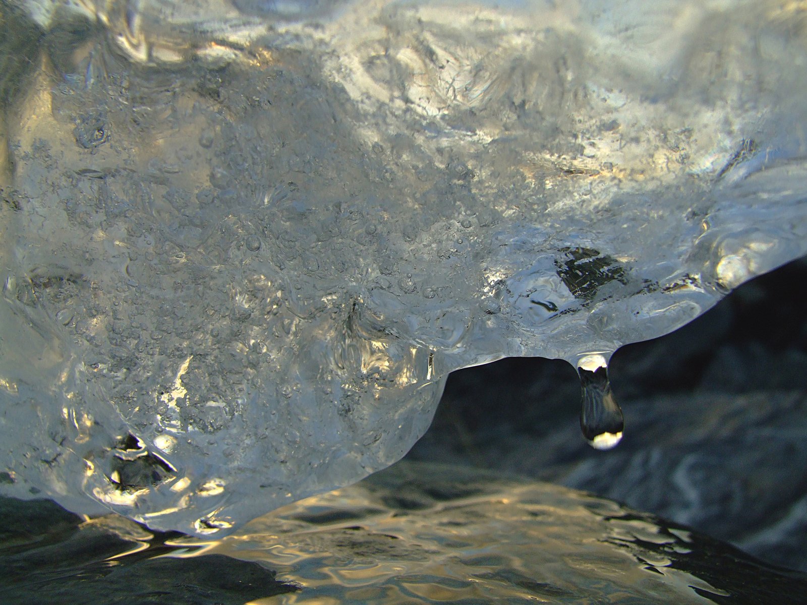 water is swirling off the side of an ice cave