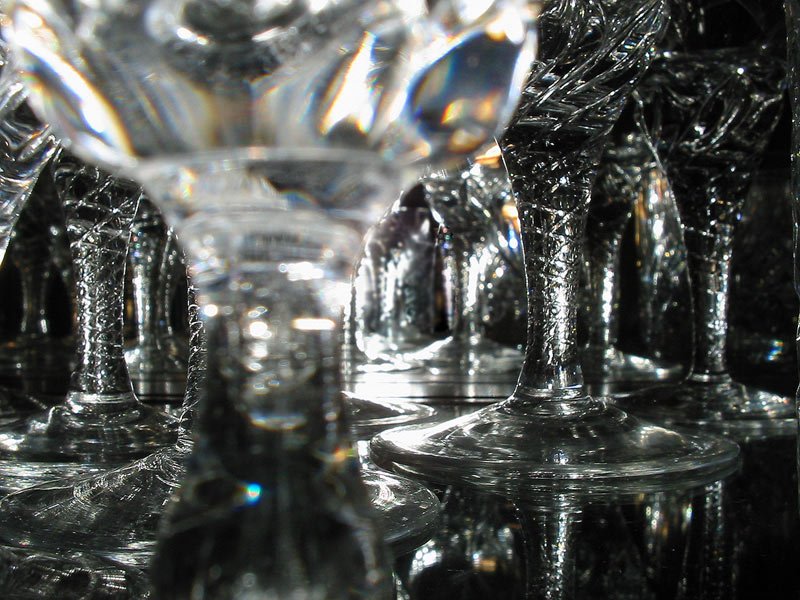 many crystal wine glasses are set up in rows