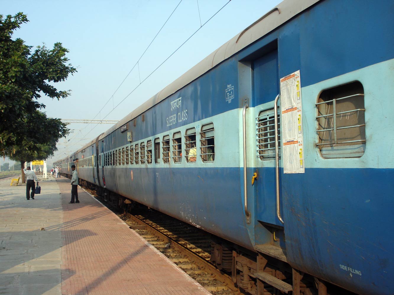the side of a blue passenger train on a track