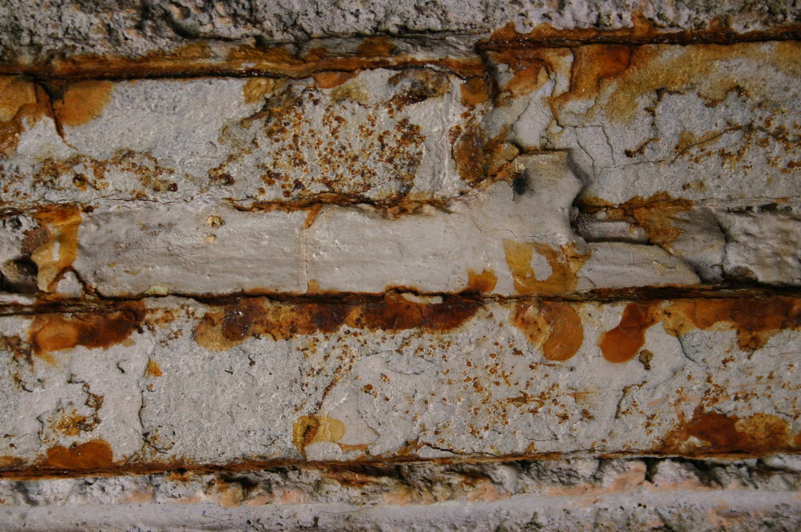 a very old brick wall with peeling paint on it