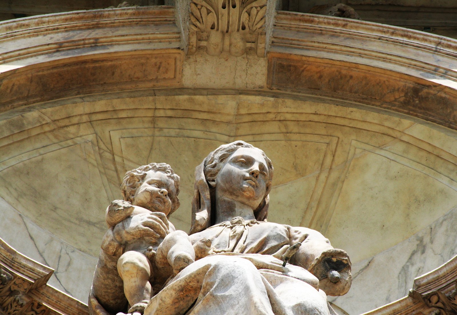 a statue of the virgin and child near a building
