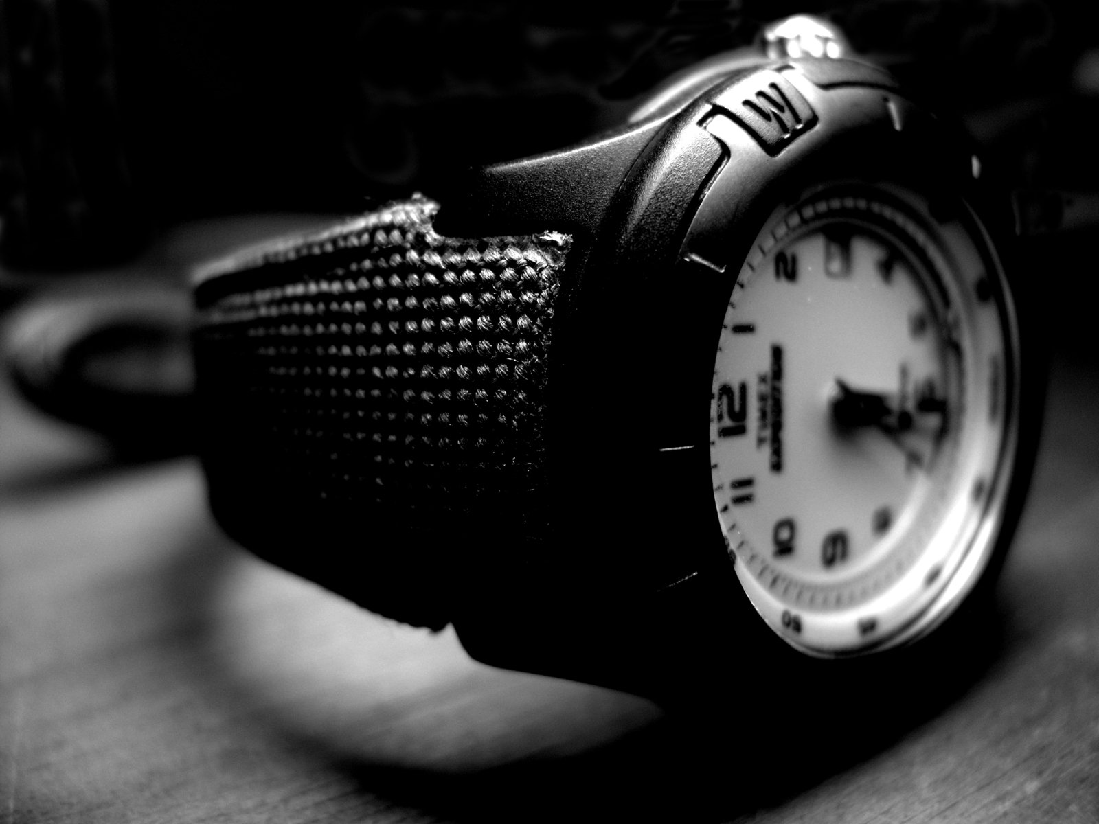 a watch on the table sits in black and white