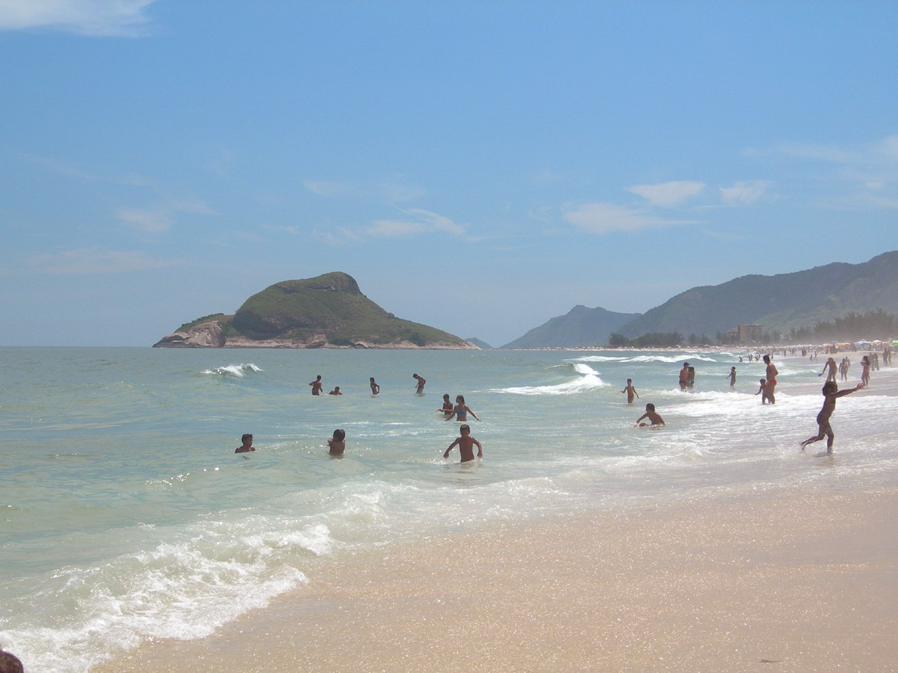 people are wading in the water at the beach