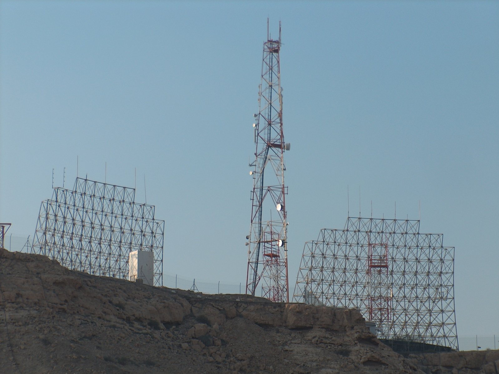several cellular towers sitting atop a hill of rocks