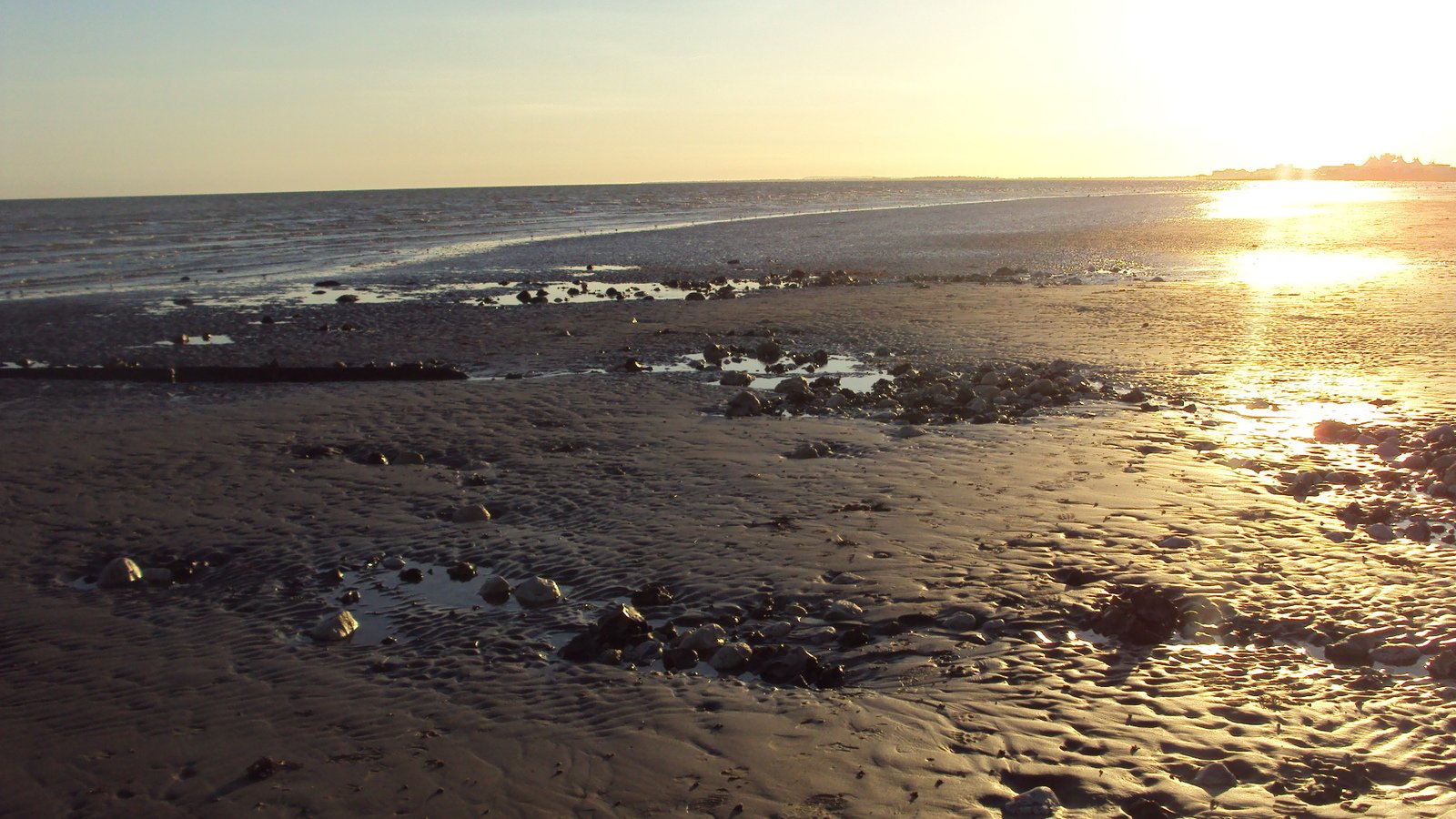 a view of the ocean and the sun reflecting in the water