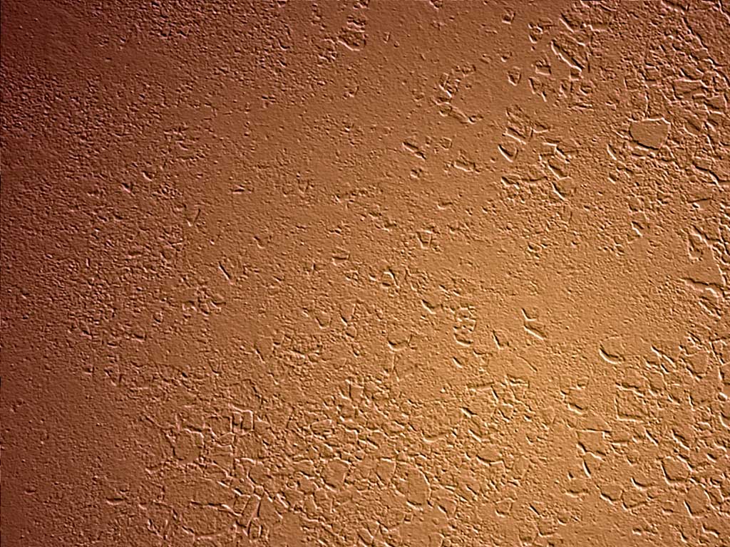 a stucco wall painted orange and brown with light dots