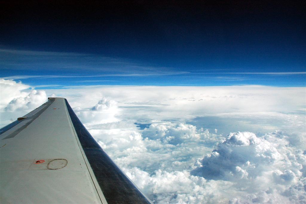 a view from the inside of an airplane shows a wing and fluffy clouds