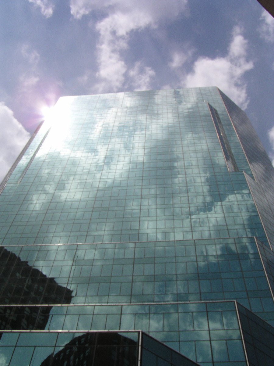 a very large glass building in front of some sky